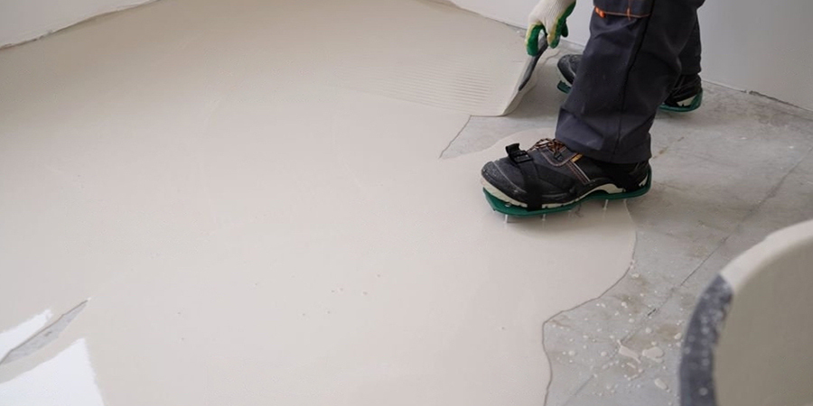 This image shows a man applying epoxy paint on the floor.